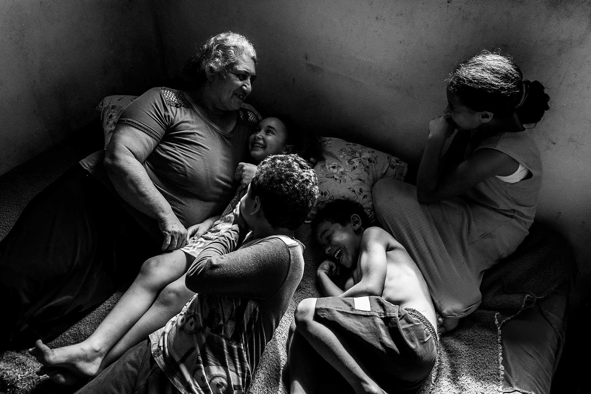 Sandra Mara Siqueira rests with her grandchildren: Ana Flávia (12), Davi Lucas (10), Micael (8) And Vitória (7), in Colombo, Paraná, Brazil. Sandra&rsquo;s family seeks land regularization to secure legal ownership of their home, which would finally allow them to invest in permanent improvements and guarantee access to basic rights like water and electricity.